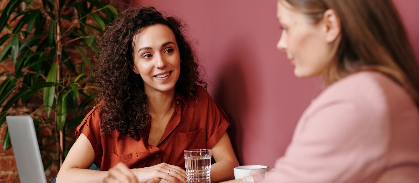 Two professionals discussing work together in a warm, calm setting.